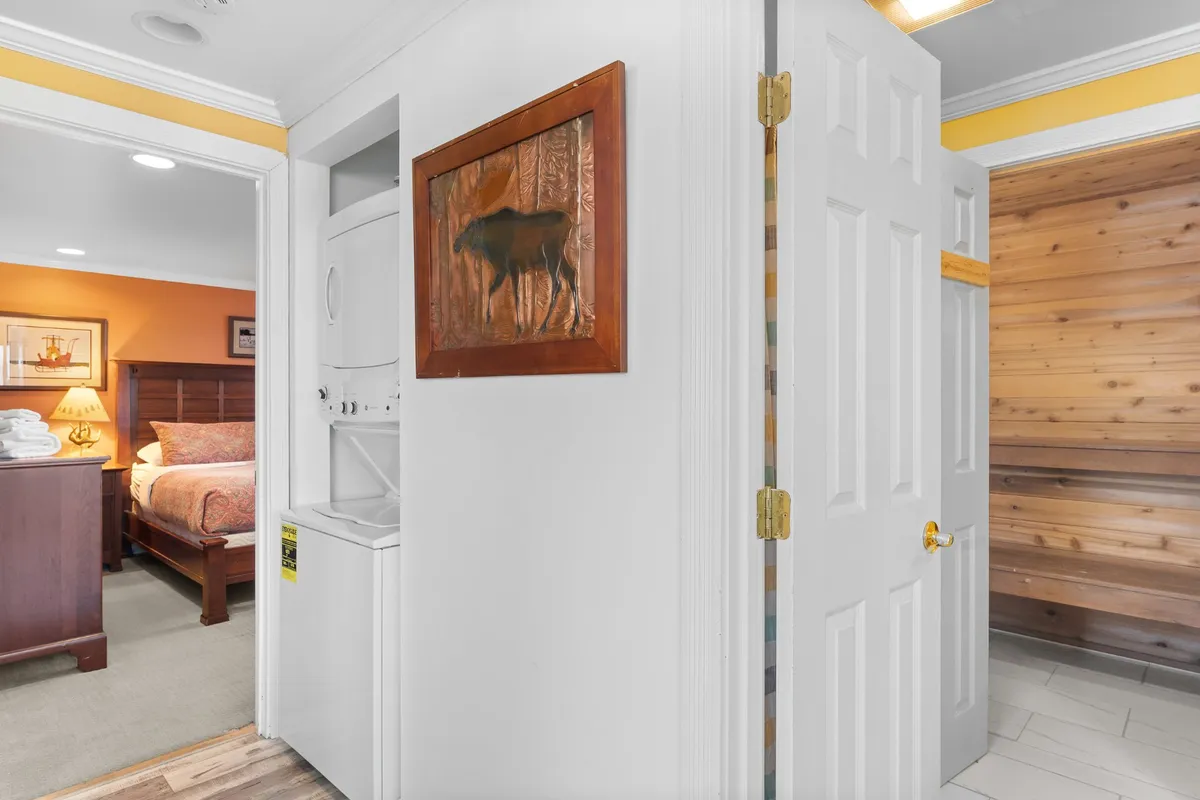 A cozy, functional space displaying a washer and dryer unit integrated seamlessly near a bedroom entry. The area is practical and emphasizes the convenience of in-unit laundry, ideal for guests planning extended stays or outdoor adventures.